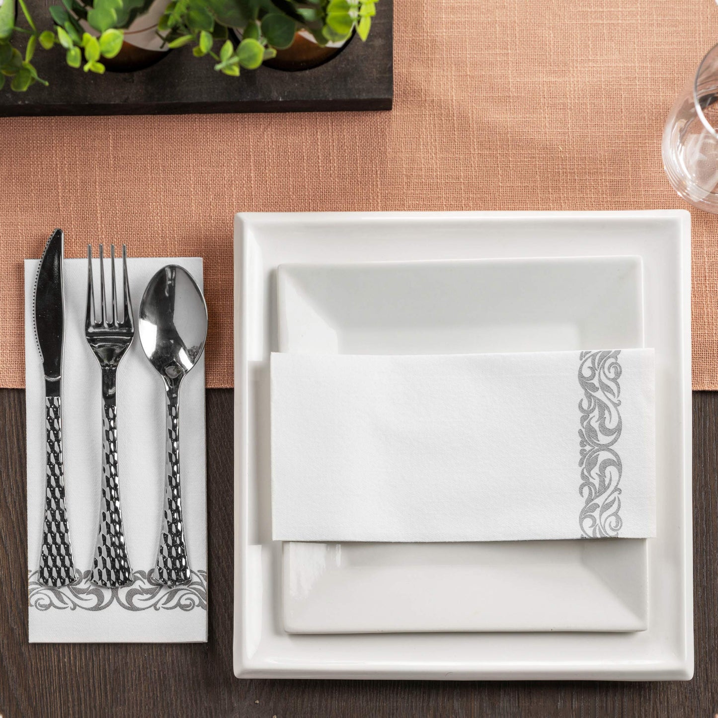 Elegant 12 inch by 17 inch guest towel with silver floral print for events displayed at a formal table setting