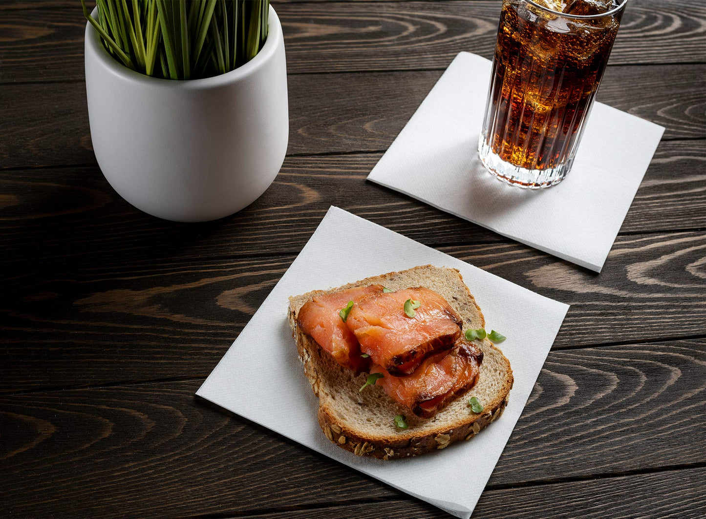 Servietto disposable linen-feel luncheon napkin underneath soda and food
