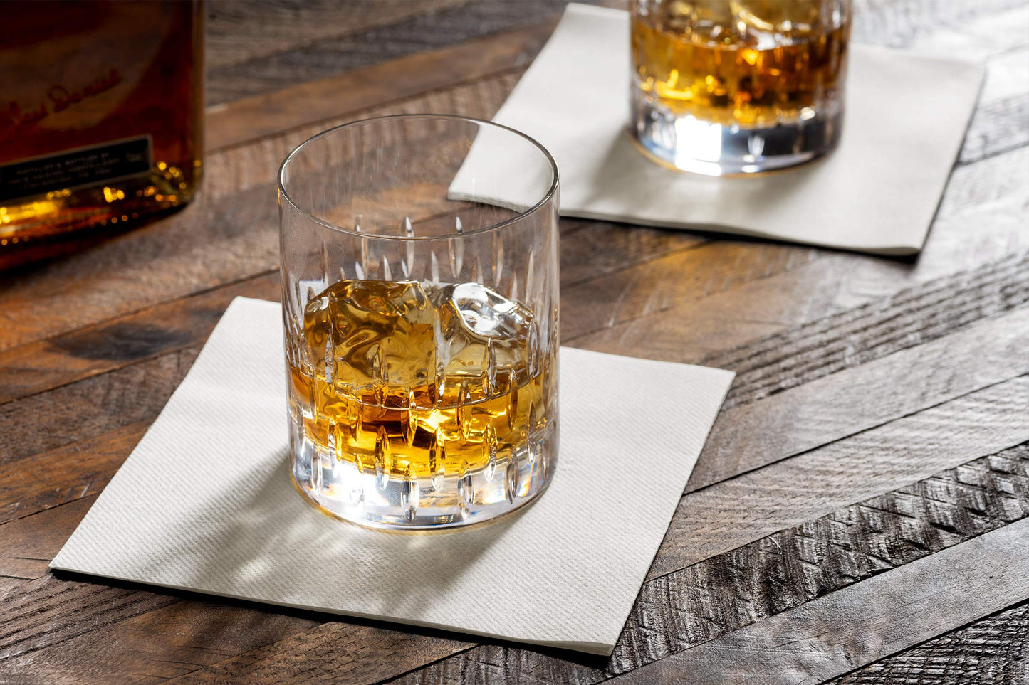 Disposable Linen-feel beverage napkin underneath a whiskey glass