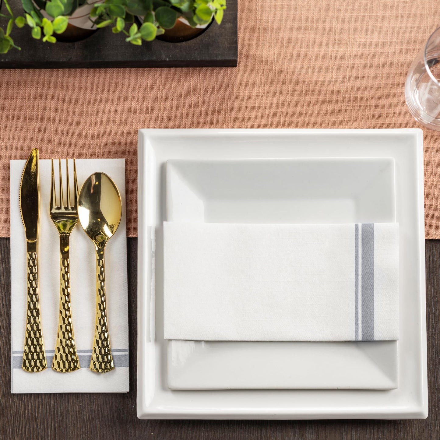 Disposable linen-feel napkin in silver trim at upscale event table setting