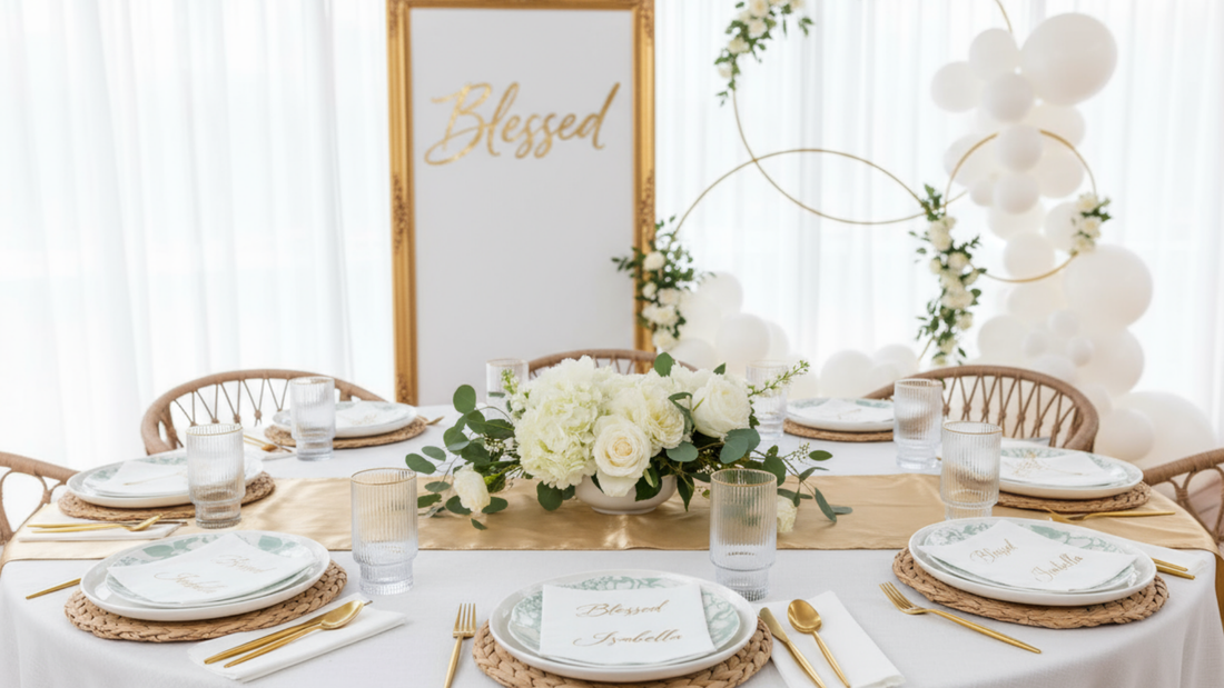 Elegant white and gold baptism party table with "Blessed" sign, floral centerpiece, and Naptec napkins at each place setting.
