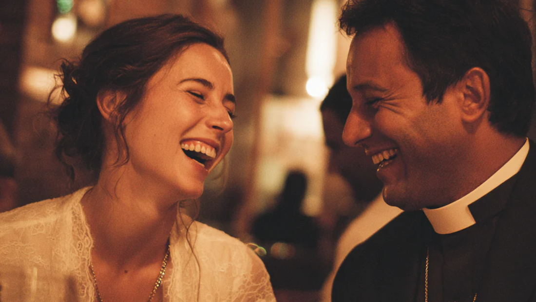Man and woman sharing a joyful moment at a First Communion celebration dinner.