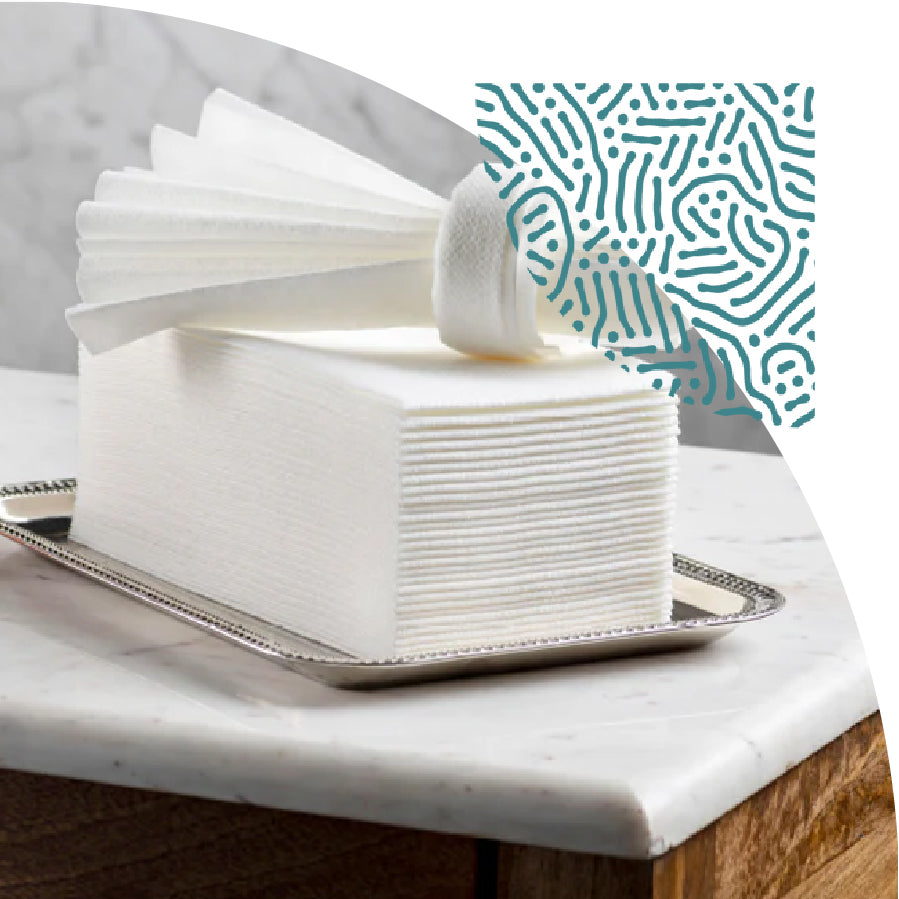 Stack of white disposable guest towels from Lintext on a silver tray with a marble surface underneath