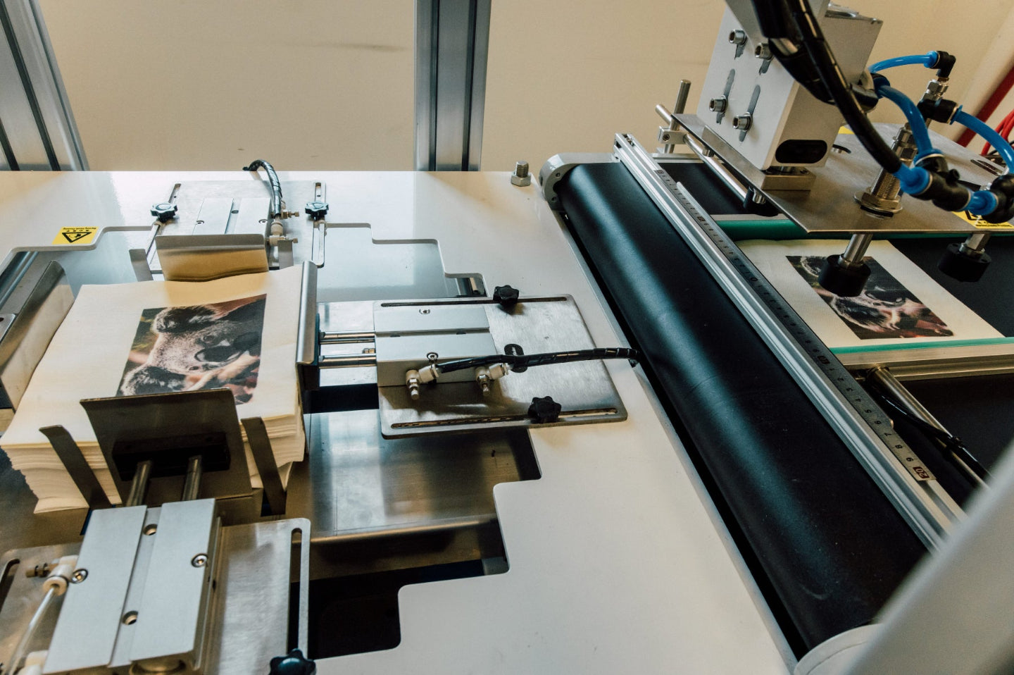 Custom napkin printing press machine with paper and ink rollers on a light-colored surface.