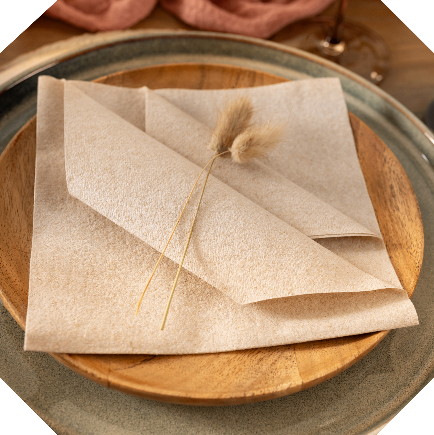 Folded brown paper with a dried plant on a wooden plate